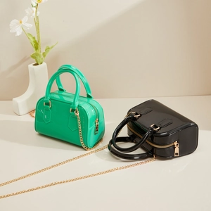 Détail de sacs jelly tendance en PVC vert et noir avec chaînes dorées et poignées