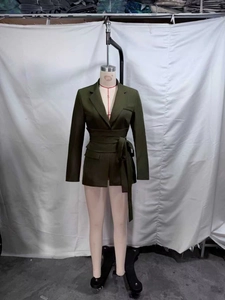 Détail d'un blazer vert olive avec revers classiques et ceinture à nouer à la taille