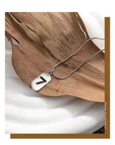 Detailed view of silver lucky number 7 pendant on snake chain over white ceramic background