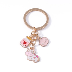 Cute golden keychain with pink enamel charms of cow, milk bottle and smiling cloud pendant