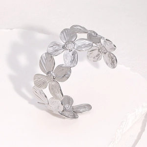 Vue détaillée du bracelet jonc argenté avec motifs de fleurs à cinq pétales entrelacées