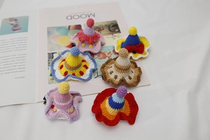 Detail view of six handmade crochet mini hats with colorful yarn and fluffy pom-poms