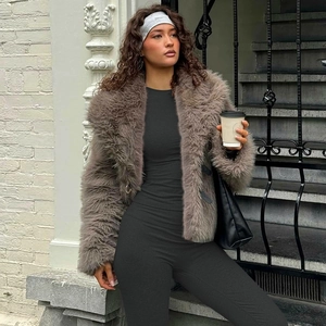 Detail of a brown faux fur coat with a black slim outfit and stylish grey headband