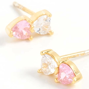 Elegant gold heart earrings with pink and clear zircon crystals on a white surface