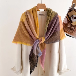 Detail of colorful plaid cashmere-feel scarf featuring stylish tassel edges and soft texture