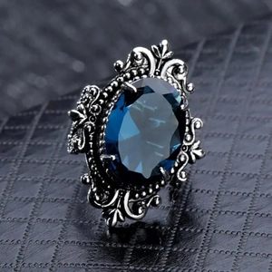 Anello vintage in stile reale con grande gemma blu ovale e rilievi floreali decorati