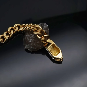 Hip hop gold Cuban link bracelet featuring a rhinestone sneaker pendant on a dark stone