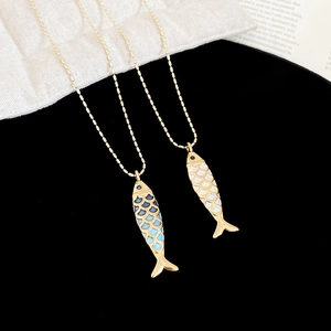 Close-up of enamel fish pendants with blue and white scales on gold bead chains
