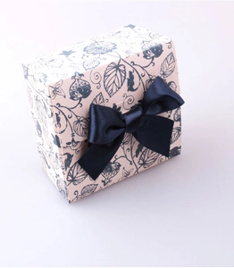 Detail of floral pink gift box with navy ribbon bow in a high-quality 45-degree view