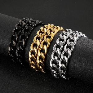 Detailed view of Cuban link chains in black, gold, and silver on a textured display