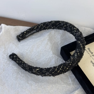 Detail of handmade black and gold plaid tweed headband with interior brand label