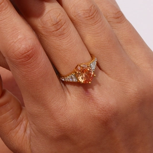 Detail of 18K gold plated ring featuring an orange oval stone and rectangular diamonds