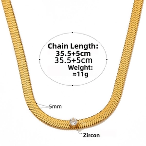 Macro detail of a 5mm gold flat snake chain necklace with a central white zircon stone