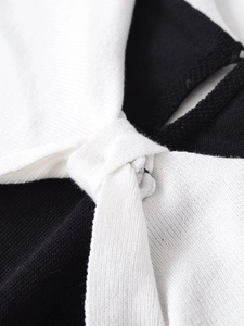 Close-up of black and white ribbed knit fabric with decorative bow knot detail