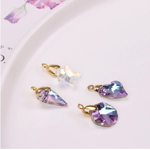 Macro shot of colorful iridescent crystal pendants in heart and star shapes for DIY jewelry