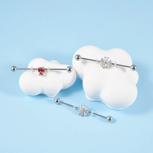 Detailed close-up of industrial piercing rods with red heart, flower and snowflake charms