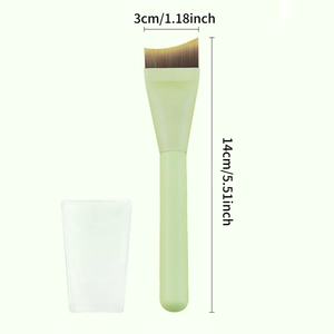 Light green blade foundation brush with curved angled head and protective dust cap