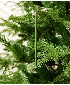 Close-up of green pine scented sticks with silver S-hooks hanging on a Christmas tree