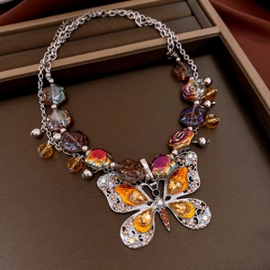 Detailed macro of vintage silver butterfly necklace with colorful crystals and rose beads