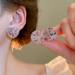 Detail of colorful crystal paved heart and ball stud earrings shown on model