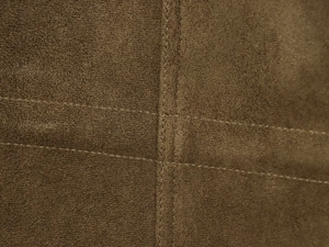 Gros plan détaillé du tissu en daim marron avec des coutures doubles précises et fines