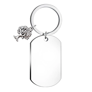 Polished stainless steel dog tag and tree of life charm detail on a keychain