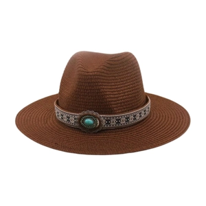 Détail d'un chapeau de paille à large bord avec ruban ethnique et pierre turquoise
