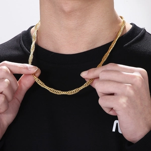 Macro detail of men's chunky gold snake chain necklace with irregular wave texture