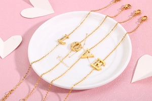 Macro detail of four-piece gold LOVE letter bracelets with sparkling rhinestones