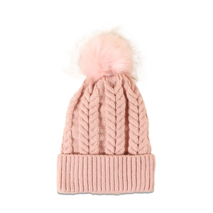 Detailed close-up of pink cable knit beanie with fluffy faux fur pompom and ribbed cuff