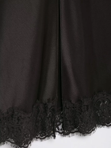Détail du tissu satiné noir avec bordure en dentelle montrant texture lisse et savoir-faire