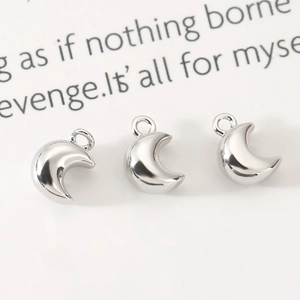 Macro detail of three polished silver crescent moon charms for DIY jewelry making