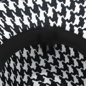 Interior detail of houndstooth fedora hat showing material label and stitching quality