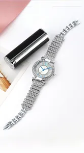 Close-up of a silver rhinestone watch with light blue hands on pink leather texture