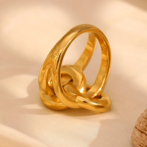 Macro shot of 18K gold plated double-layer knotted chain ring on beige silk fabric