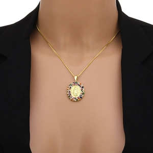 Collier en or Vierge Marie avec pendentif en zircon coloré sur un costume noir