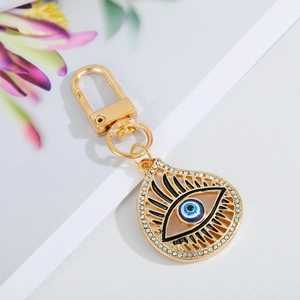 Close-up of teardrop evil eye keychain with gold plating and sparkling rhinestones