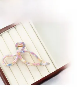 Detail of colorful acetate hair claw clip with golden metal spring in a jewelry box