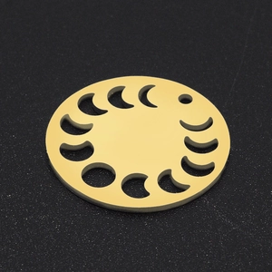 Macro detail of golden moon phase cut-out charm on textured black background
