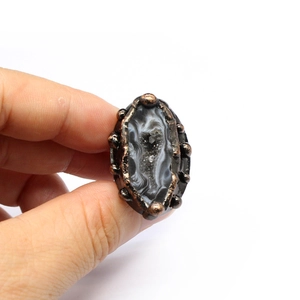 Detail of vintage bronze ring featuring natural black and white agate geode stone