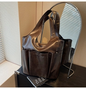 Detail of dark brown leather tote bag with multi-pockets and retro commuter aesthetic