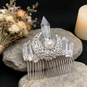 Detailed close-up of natural crystal moon hair comb with raw quartz and filigree details