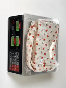 Corduroy storage bag with strawberry print being weighed for shipping weight check