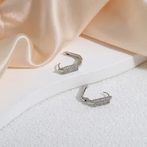 Chic silver U-shaped earrings with dense zircon inlay displayed on silk fabric
