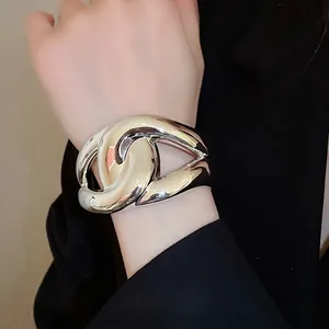 Chunky silver metal interlocking bracelet for women styled with a black suit