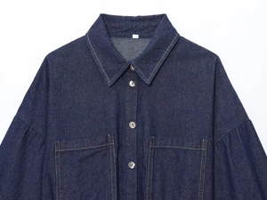 Detailed close-up of dark blue denim shirt collar featuring metal buttons and double stitching