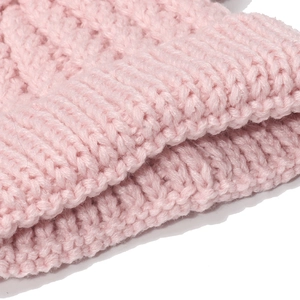 Macro detail of pink ribbed knit texture and folded cuff on children's winter beanie hat