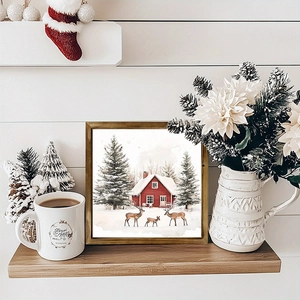 Detail of square wooden frame with watercolor winter cabin and reindeer scene for Christmas