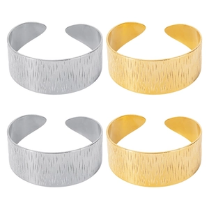 Detailed view of silver and gold C-shaped open bracelets with textured tree bark finish