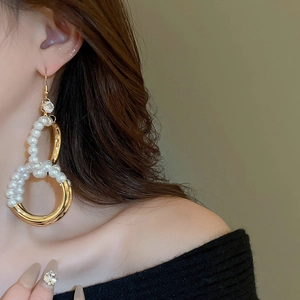 Detail von französischen Vintage-Perlenohrringen mit goldenen Ringen und Zirkon am Modell